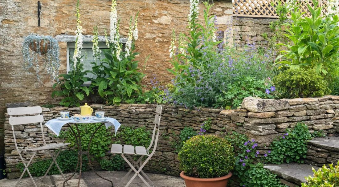 A beautiful Cotswold garden with tea for two set and wildflowers 