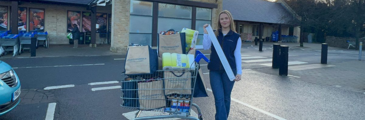 StayCotswold colleague with items in bags and long receipt outside Tesco store in Stow-on-the-Wold